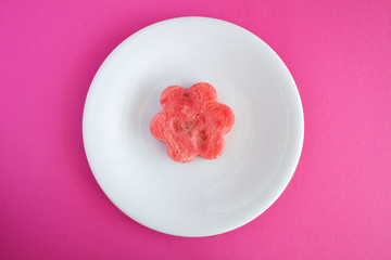 Watermelon flower in the white  plate  on the pink  background.Top view.Diet minimal concept.