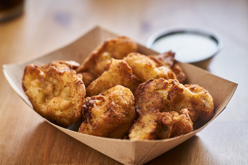 crispy fried cauliflower bites in brown paper tray