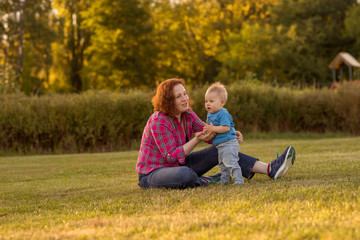 Fototapeta premium Baby first year playing with mother on the grass.