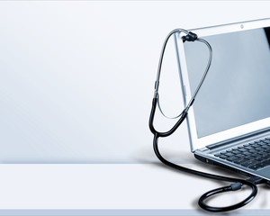 Laptop diagnosis with  stethoscope on background