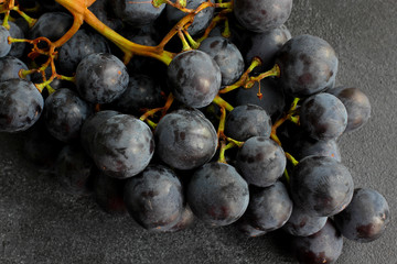 Blue grapes on dark board, close up