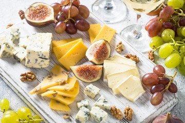 Cheese plate with grapes, figs and nuts.