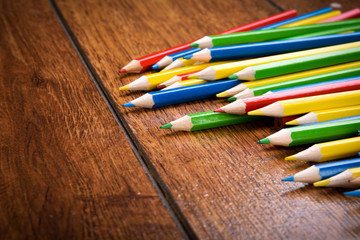 Different colored pencils on the brown wooden table background .Top view .Close up .Color .Pencil.Set