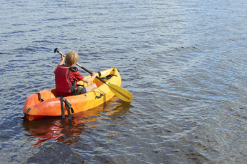 Obraz premium Active happy child. Teenage school boy having fun enjoying adventurous experience kayaking on the lake on a sunny day during summer vacation