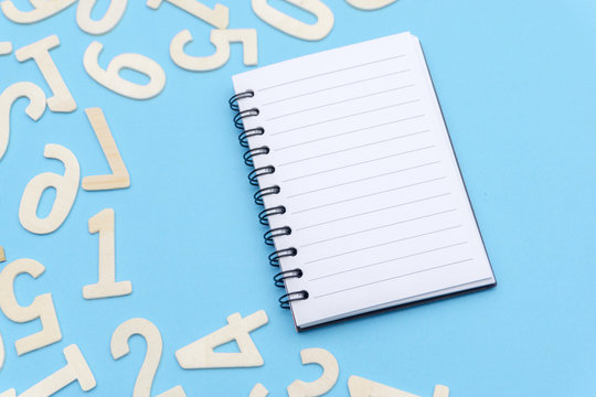 note book and scattered numbers on blue paper