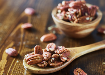 pile of pecans on wooden table shot close up
