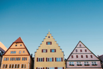 Multicolored houses with many windows against the blue sky in Rothenburg ob der Tauber in Germany.