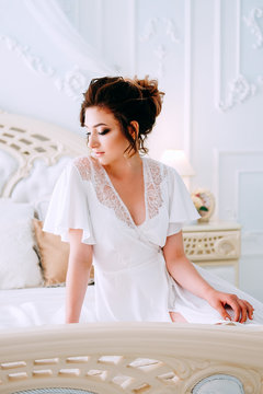 Beautiful young bride in honeymoon suite getting ready
