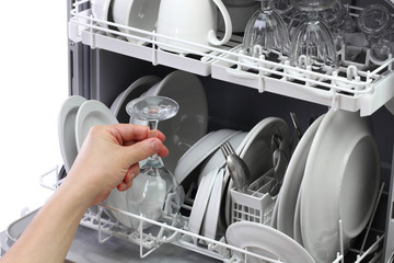 open dishwasher, man hand taking out clean wine glass, after washing
