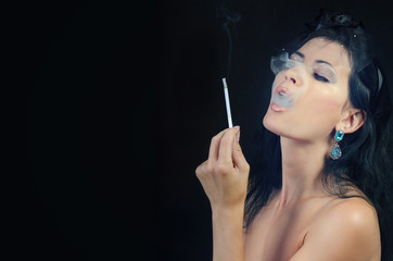 woman releasing smoke holding a cigarette in her hand
