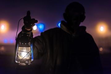 Man in the dark with a kerosene lamp