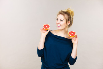 Happy smiling woman holding red grapefruit