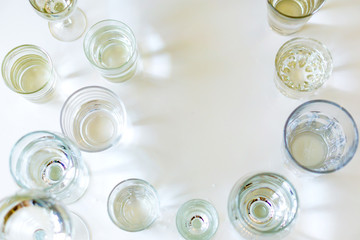 Close-up of glasses of crystal clear drinking water on a white table. Shallow depth of focus. Health concept from nature.