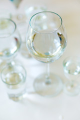 Close-up of glasses of crystal clear drinking water on a white table. Shallow depth of focus. Health concept from nature.