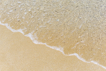 Water texture. Close-up of beach, with sun reflection, soft waves, foamed, turquoise waters and fine yellow sand on the Black Sea coast. Concept summer. Negative space.
