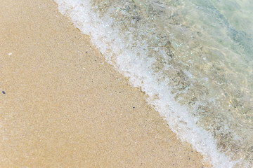 Water texture. Close-up of beach, with sun reflection, soft waves, foamed, turquoise waters and fine yellow sand on the Black Sea coast. Concept summer. Negative space.