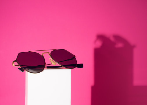 fashion sunglasses gadget object on white pole with pink color background
