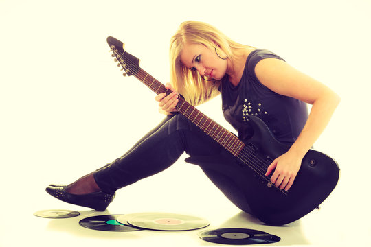 Woman with electrical guitar and vinyl record.