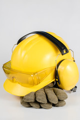 Helmet and hearing protection on a white table. Safety and hygiene accessories for construction workers.