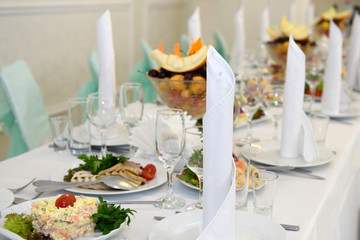 Exquisite table with food and covered with white tablecloth. Luxury feast at the Banquet. 