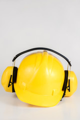 Helmet and hearing protection on a white table. Safety and hygiene accessories for construction workers.