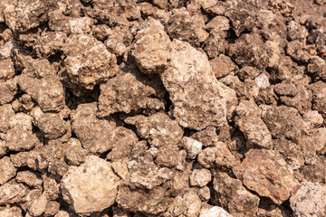 Hunsur, Karnataka, India - November 1, 2013: Closeup of brown raw limestone with with spots of lime visible. To be crushed and heated in kiln.