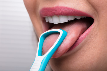 Woman Cleaning Her Tongue With Cleaner