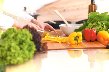 Close Up of human hands cooking vegetable salad in kitchen on the glass table with reflection. Healthy meal, and vegetarian food concept