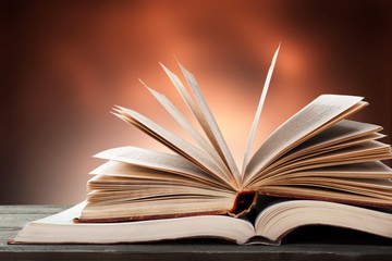 Big opened book with sparkles on background