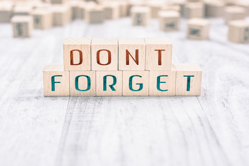 The Words Don't Forget Formed By Wooden Blocks On A White Table, Reminder Concept