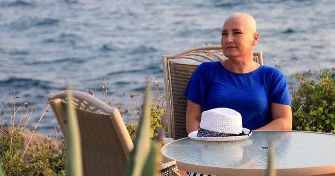 Portrait of a positive female cancer patient sitting and relaxing near the sea