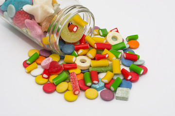 Colorful candy in a jar on a white background
