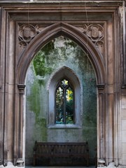 Gothic facade and gate with wooden bench. 