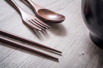 Wooden Set Of Fork, Knife And Chopsticks Next To A Bowl On A Table - Eating Chinese Food Concept