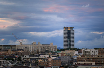 Fototapeta na wymiar Tall apartment building against clouds at sunset in northern Osaka