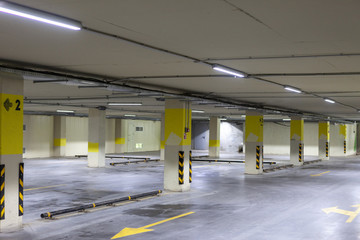 Empty underground parking. Even rows with bright markings.