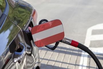 Fueling car with petrol pump at a gas station.
