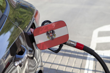 Fueling car with petrol pump at a gas station.