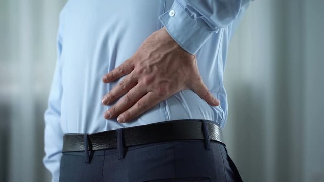 Businessman feeling lower back pain, nerves inflammation, kidneys disorder
