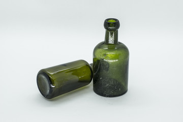 two old green bottles, one standing and the other lying down isolated