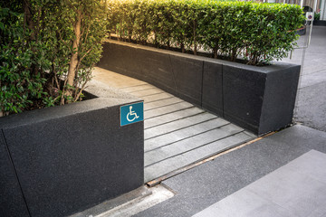 Ramped access, using wheelchair ramp with information sign on floor background