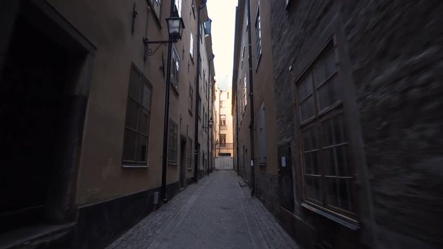 An old dark alley in the Old Town of Stockholm Sweden. Steady glide cam footage moving forward. A narrow street in the historical gamla stan. Empty street with no people.