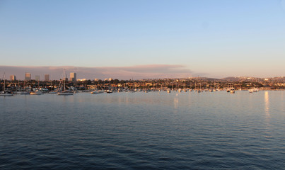 Newport Beach Harbor at dusk with clouds from fire on the horizon