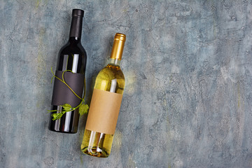 Flat lay of lying organic wine bottles with empty labels and green vine