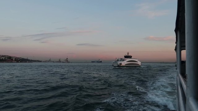 Wide angle shot of ferry going from Europe to Asia in Istanbul's Bosphorus during sunset (regular speed)