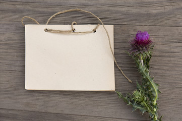 Wildflower with handmade craft notebook on old grunge wooden background. Top view. Minimalistic mockup.