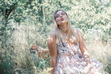 A woman of plus size, American or European appearance walks at park enjoying life. A middle age lady with excess weight, in a stylish dress 