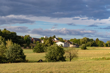 Fototapeta na wymiar Small village in a rural landscape under blue sky in summer