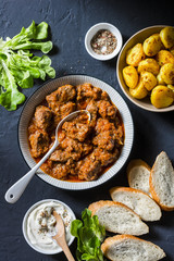 Irish beef stew and turmeric potatoes - delicious seasonal lunch on a dark background, top view. Flat lay