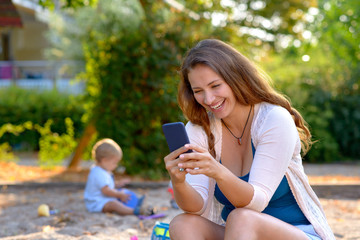 Young mother laughing at a text message